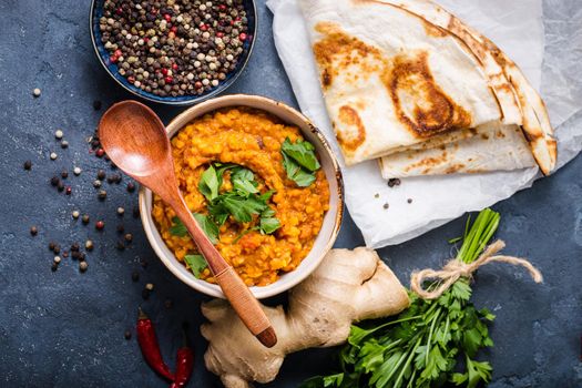 Traditional Indian lentils Dal, naan butter bread. Space for text. Indian Dhal spicy curry in bowl, spices, herbs, rustic concrete background. Top view. Indian food. Authentic Indian dish. Copy space