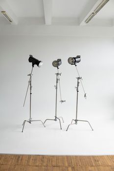Professional lighting equipment, flashes, c-stands on a cyclorama in modern photo studio. Octabox, stripbox, softbox, buety plate and other stuff for photography