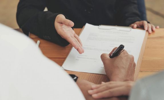 A lovely couple in the meeting with their real estate agent to sign the house contract. Property investment concept. cropped image.