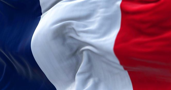 Close-up view of the France national flag waving in the wind. France is a country located in Western Europe. Fabric texture background. Selective focus