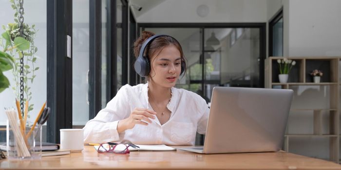 close up of Student learning online class by using laptop computer and writing notebook at workplace, E learning and online working concept..