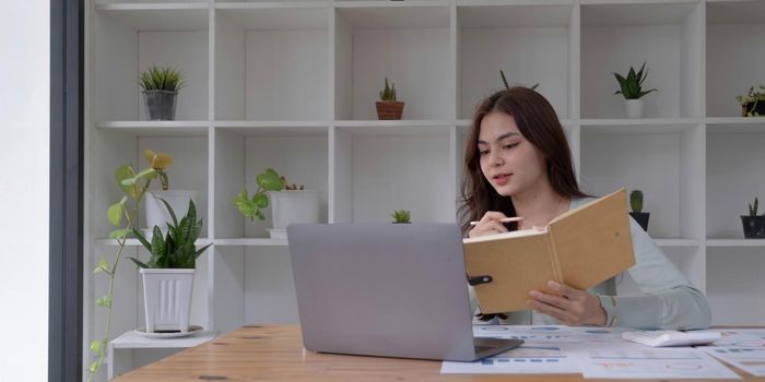 Concentrated female student busy studying using laptop make notes in notebook, focused man worker employee write watching webinar or online training course on computer, education concept.