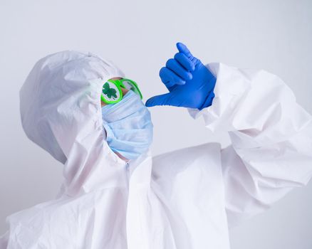 A woman in a protective suit and mask and glasses for st patrick's day gestures booze. A traditional Irish holiday.