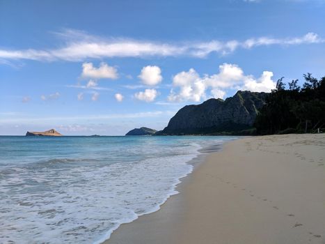 Gentle wave lap on Waimanalo Beach looking towards Rabbit island and Rock island on a nice day Oahu, Hawaii.  December 11, 2017.