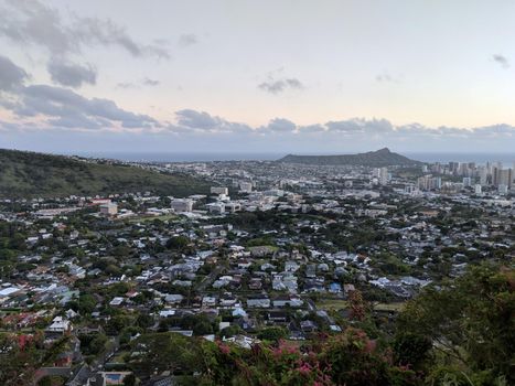 Diamondhead and the city of Honolulu, Kaimuki, Kahala, and oceanscape on Oahu on a nice day at dusk viewed from high in the mountains with tall trees in the foreground. Taken on November 23, 2017.