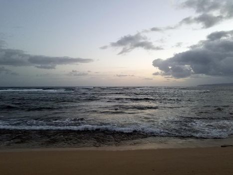 Shallow wavy ocean waters of Camp Mokuleia Beach looking into the pacific ocean with at dusk on Oahu.