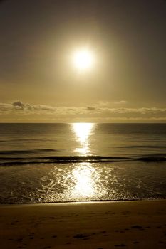 Early Morning Sunrise reflecting on the water on Waimanalo Beach on Oahu, Hawaii over the clouds. 2016.