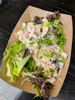 Veggie Poke Salad in a paper tray on a black table.