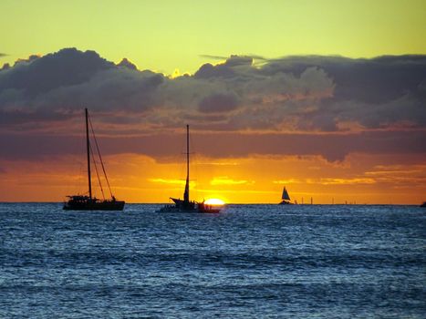 Boats on the pacific ocean waters of Waikiki at Sunset on Oahu, Hawaii.