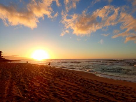 Beautiful Sunset over the ocean with waves moving to shore Sunset Beach on the North Shore of Oahu.    