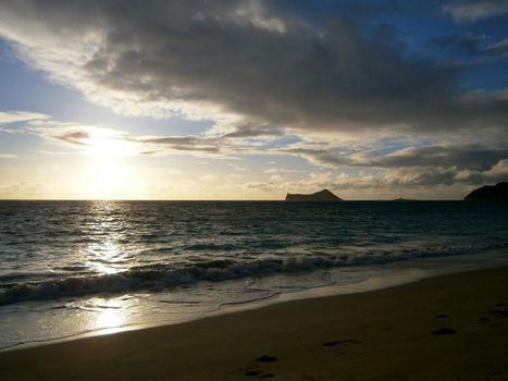 Early Morning Sunrise on Waimanalo Beach on Oahu, Hawaii bursting through the clouds. 2012.