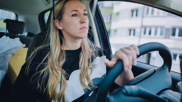 A young woman driving a car is driving on the highway