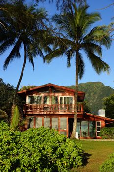Red Beach House and coconut trees in Waimanalo on a Beautiful Day on Oahu, Hawaii.                               