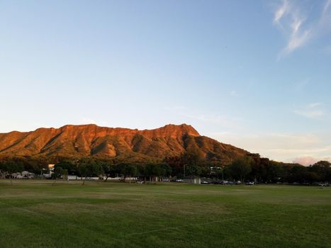 Kapiolani Park at dusk with Diamond Head and clouds in the distance on Oahu, Hawaii.