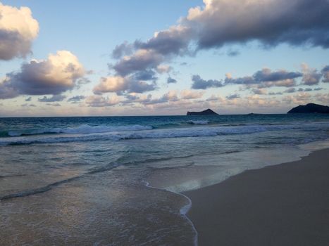 Gentle wave lap on Waimanalo Beach looking towards Rabbit island and Rock island on a nice day Oahu, Hawaii.  October 13, 2016.