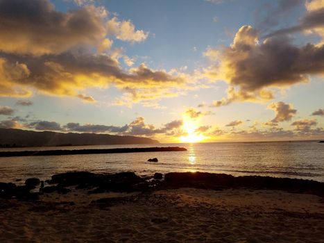 Beautiful Sunset over the ocean along rocky shore at Hale'iwa Beach Park on the North Shore of Oahu.    