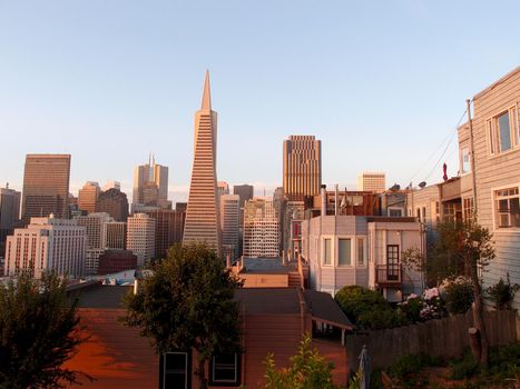 San Francisco - June 14, 2013: San Francisco Skyline at Dusk with the Transamerica pyramid, Bank of America building, houses, trees, and other downtown buildings visible in the background.