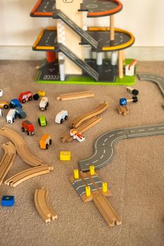 A scattered wooden road construction kit on the floor. Child's play.