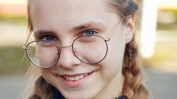 A teenage girl wearing glasses. Close-up of her face