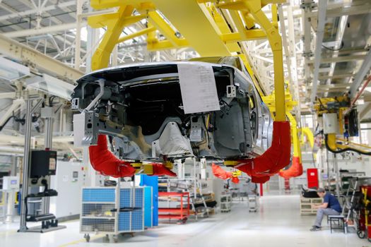 Factory for the production of cars, factory conveyor. Cars are being assembled.