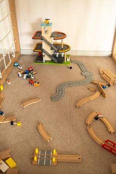 A scattered wooden road construction kit on the floor. Child's play.