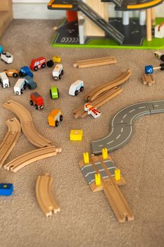 A scattered wooden road construction kit on the floor. Child's play.