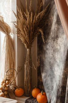 Autumn interior in a photo studio, with pumpkins and dry grass.