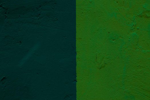 Abstract background of two shades of green on a concrete wall.