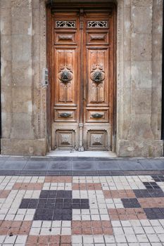 Old wooden door and vintage lion face shaped knocker in Spain