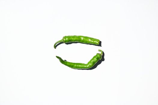 Flat lay composition. Horizontal studio shot of green chili peppers, isolated on white background. Copy ad space. Top view