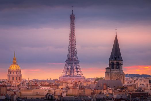 Eiffel tower and parisian roofs at dramatic sunrise Paris, France