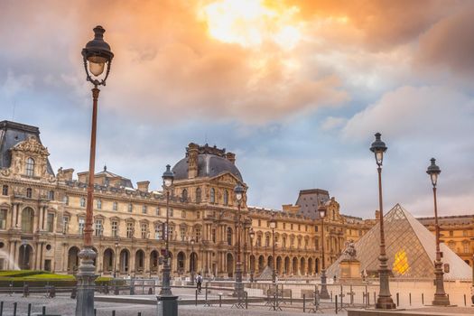 Louvre square with street lights from Tuileries and dramatic sky, Paris, France
