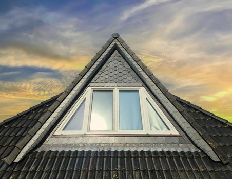 Open roof window in velux style with black roof tiles