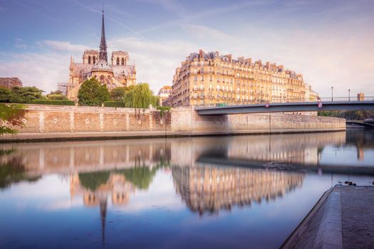 Notre Dame of Paris on Seine River reflection at peaceful sunrise, France