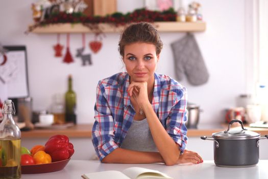 Smiling woman in the kitchen, isolated on christmas background