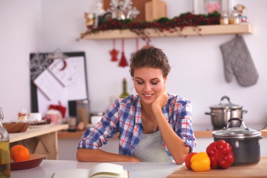Smiling woman in the kitchen, isolated on christmas background