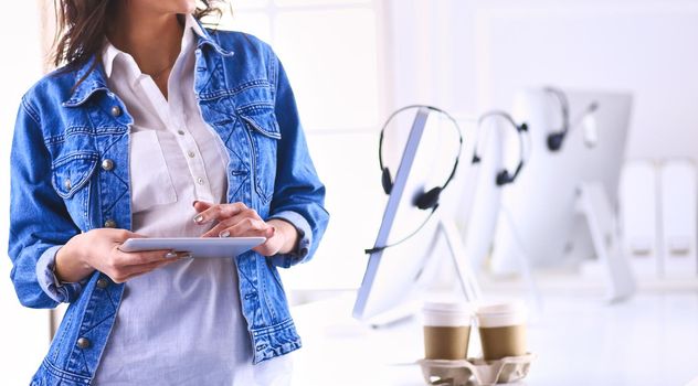 Smiling woman drinking coffee and using tablet in the cafe