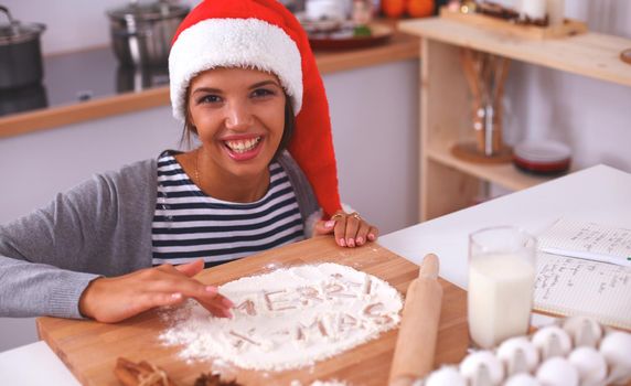 Christmas baking santa woman smiling happy having fun with Christmas preparations wearing Santa hat