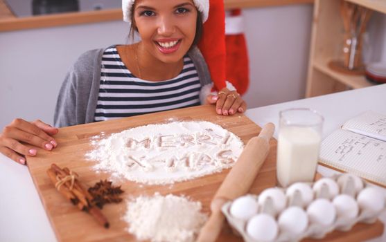 Christmas baking santa woman smiling happy having fun with Christmas preparations wearing Santa hat