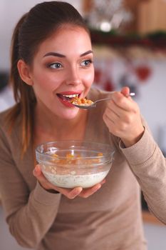 Smiling woman having breakfast in kitchen interior