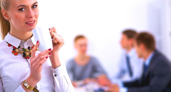 Portrait of a young woman working at office standing .