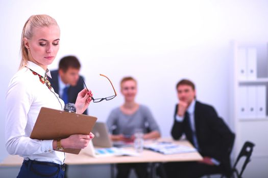 Portrait of a young woman working at office standing with folder . Portrait of a young woman. Business woman.