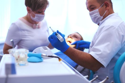 Detail of hand holding dental tools in dental clinic. Dentist Concept.