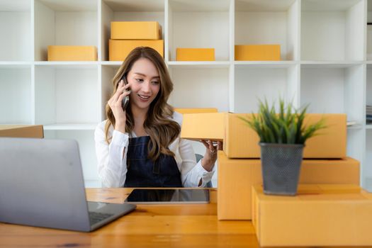 Attractive Asian SME business woman checking order at warehouse