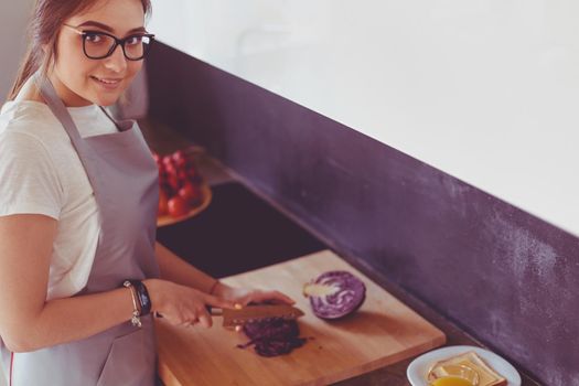 Young woman using a tablet computer to cook in her kitchen.