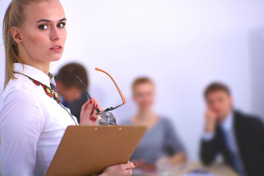 Portrait of a young woman working at office standing with folder .
