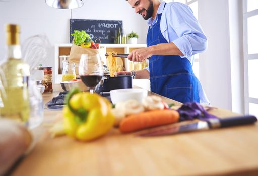 Man preparing delicious and healthy food in the home kitchen.