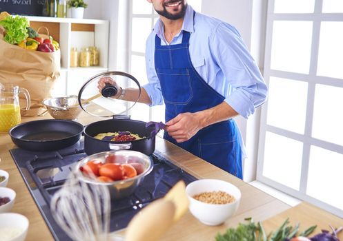 Man preparing delicious and healthy food in the home kitchen.