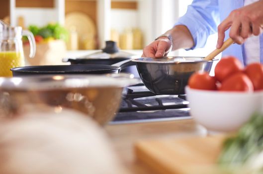 Man preparing delicious and healthy food in the home kitchen.