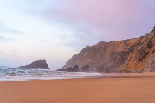 Ocean wild beach stormy weather. Praia da Adraga sandy beach with picturesque landscape background, Sintra Cascais, Portugal Vitality of blue energy and clear ocean water